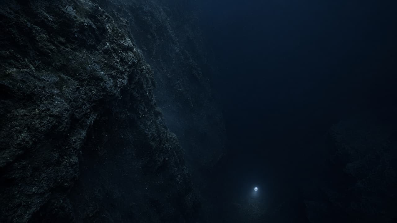 A steep hadal trench wall dropping into darkness with a tiny probe light far below